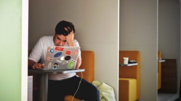 Um rapaz que pode ser um estudante a usar um computador